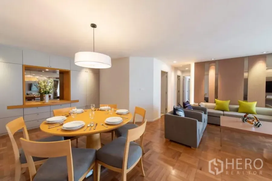 Apartment for rent - Open-plan dining and living area with round table, pendant light, built-in cabinetry and parquet floors in a Bangkok apartment near MRT Lumphini.