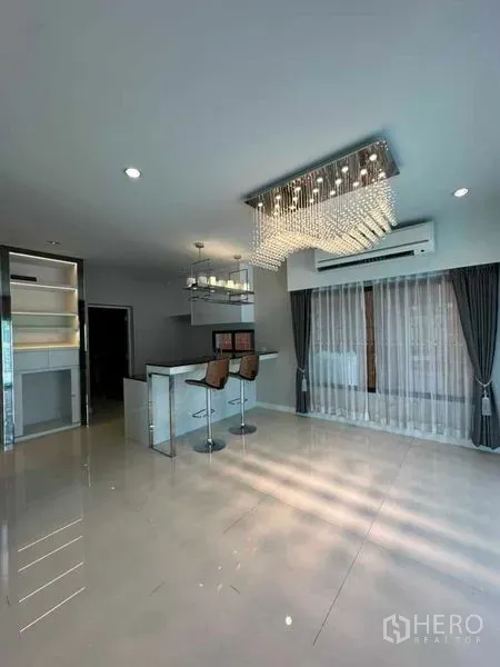 Detached House for sale in Prawet, Bangkok - Bright open-plan living and dining area with island bar and crystal chandelier.