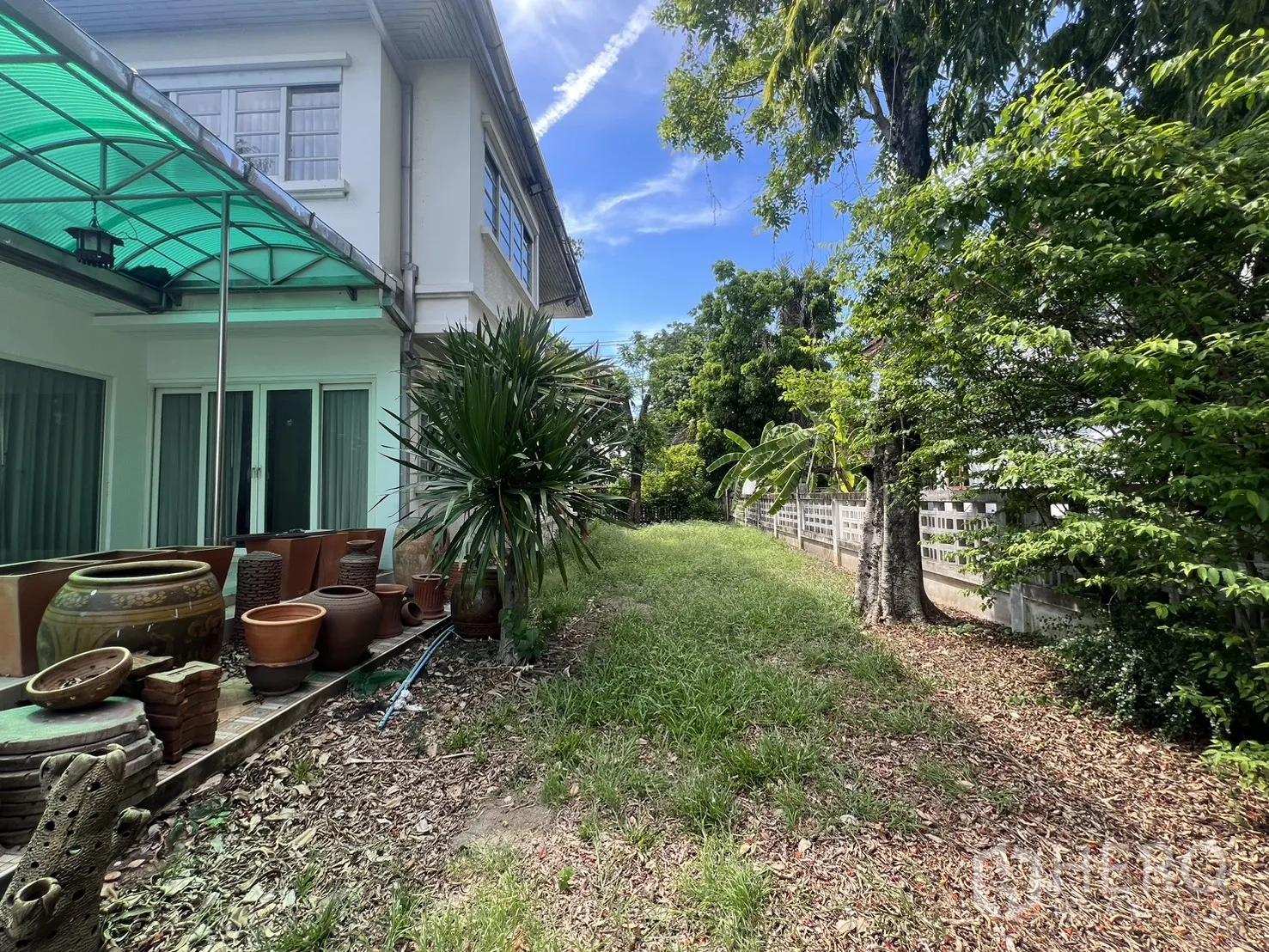 Detached House for sale in Saphan Sung, Bangkok - Side garden with green awning over terrace and potted jars.