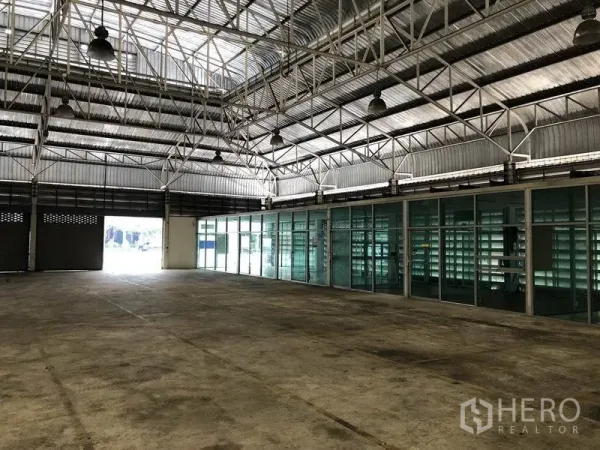 Warehouse for rent in Bang Sue, Bangkok - High-ceiling loading area with interior glass offices and natural light at the warehouse entrance.