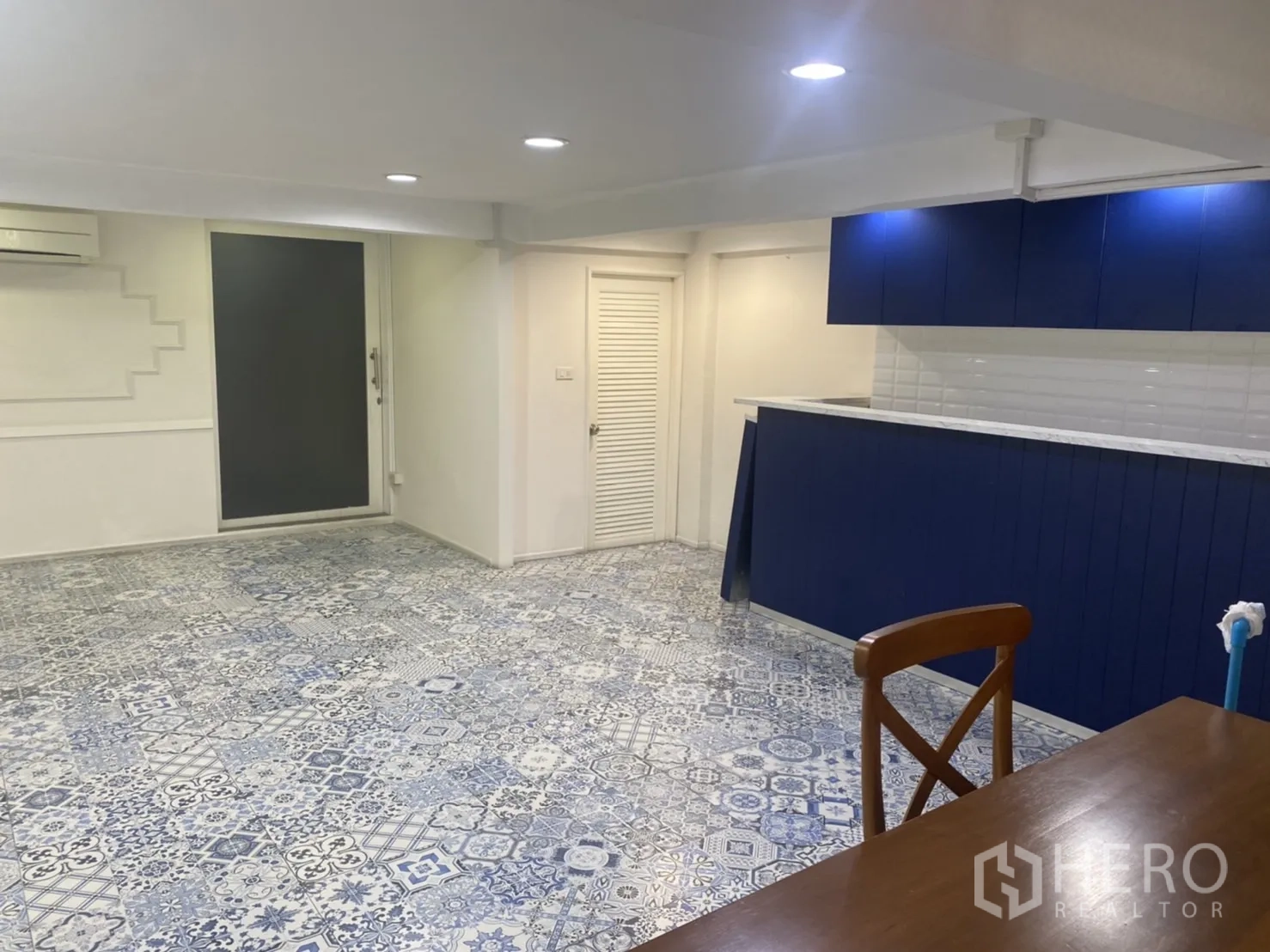 零售空间 出租在Bang Rak, Bangkok - 低层高区域的海军蓝吧台与储物柜，吊顶嵌灯照明。