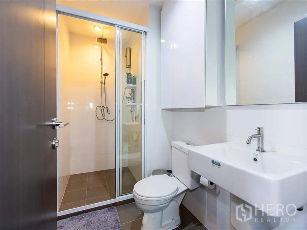 公寓 出租或出售在Watthana, Bangkok - 现代卫浴，玻璃淋浴间、坐便器与台盆一体柜。