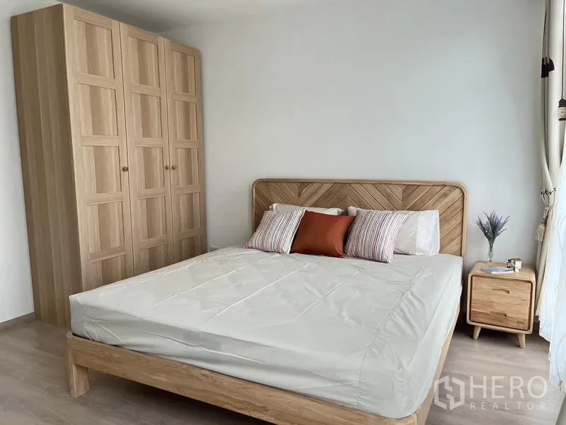 联排别墅 出租在Prawet, Bangkok - 主卧配大床、木质衣柜、床头柜与充足自然光。