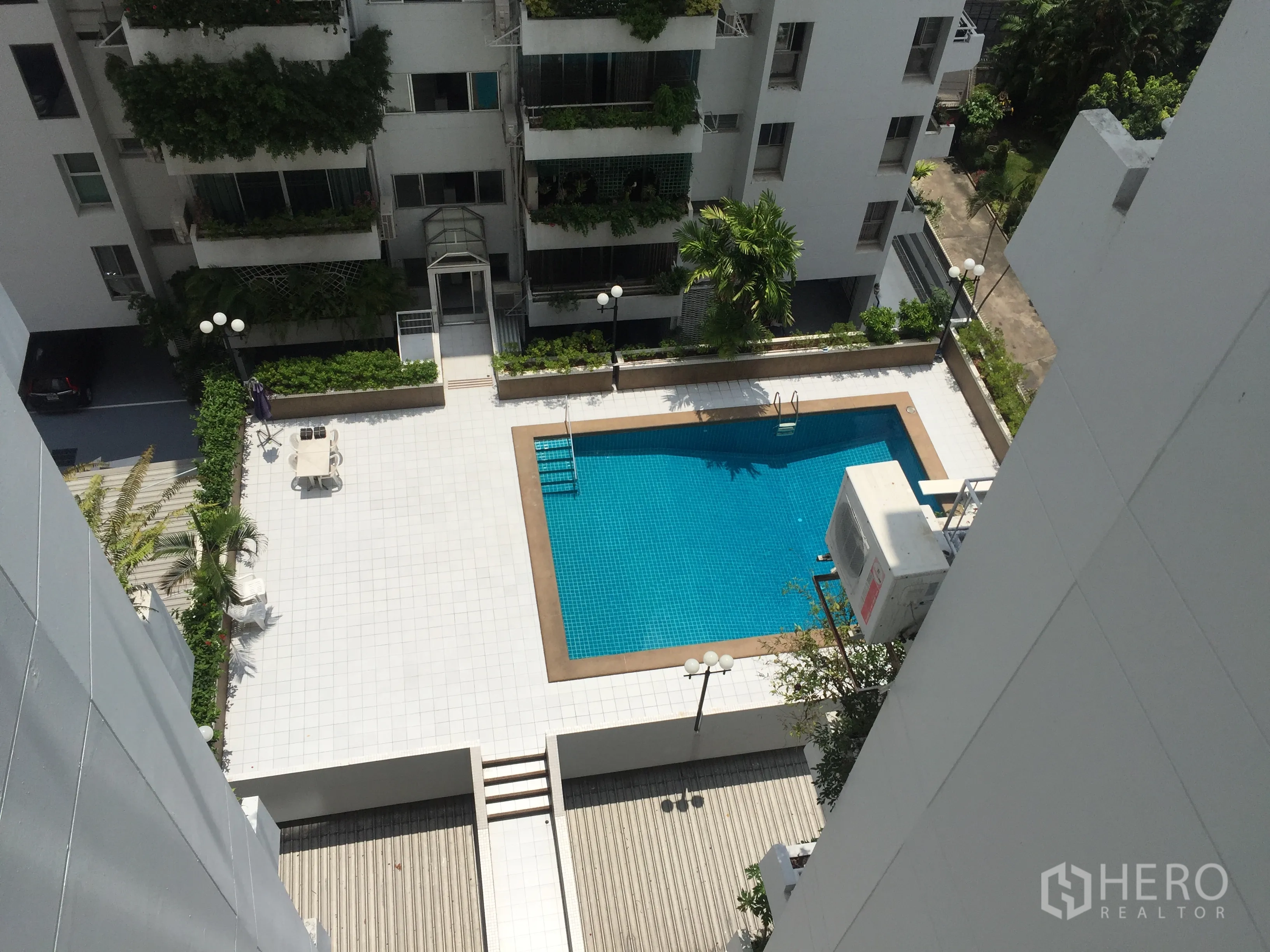 Condominium for rent in Sathon, Bangkok - Outdoor condominium swimming pool with sun deck and landscaped surrounds seen from above.