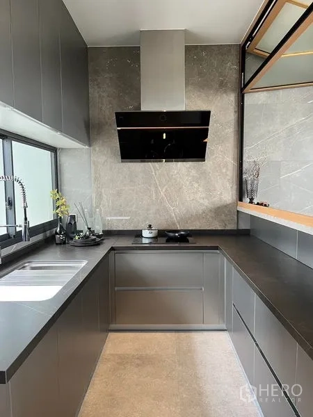 Home Office for sale in Prawet, Bangkok - Contemporary U-shaped kitchen with stone countertops, sink, and stainless-steel range hood.