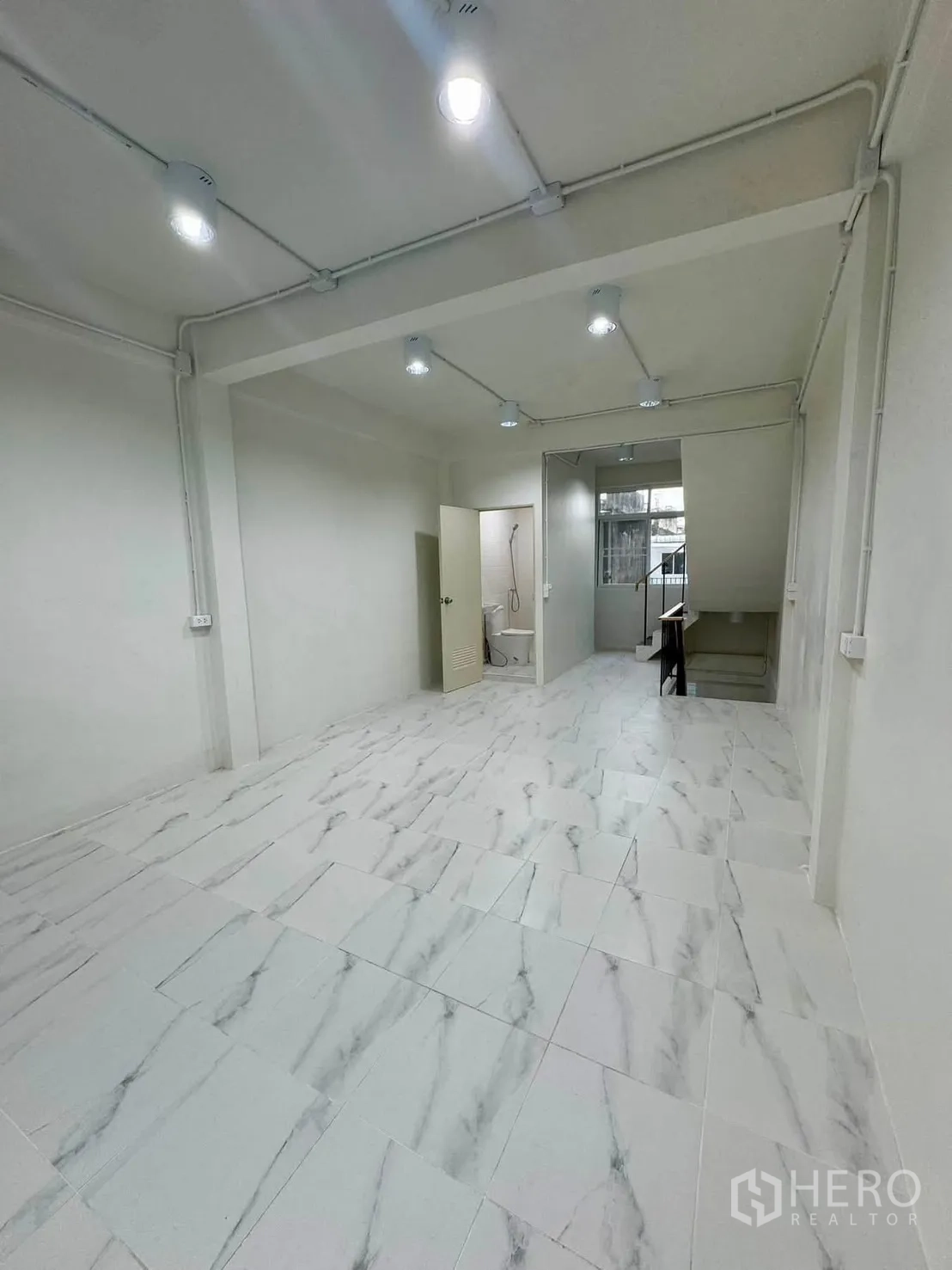 Shophouse for rent in Sathon, Bangkok - Long open area with bathroom door and stair access.