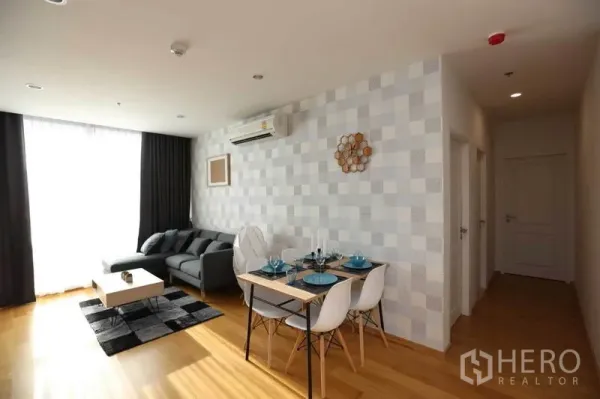 คอนโด ให้เช่าหรือขายในBang Rak, Bangkok - พื้นที่นั่งเล่นและทานอาหารสว่าง โซฟาสีเทา โต๊ะทานอาหาร 4 ที่ และผนังลาย