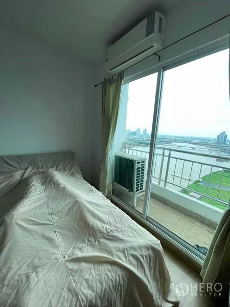 คอนโด ขายในBangkok - ห้องนอนแขกมีประตูระเบียง เครื่องปรับอากาศ และวิวแม่น้ำเปิดโล่ง