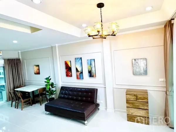 联排别墅 出租 - 客厅配现代吊灯与墙面装饰画，一旁是临窗餐桌。