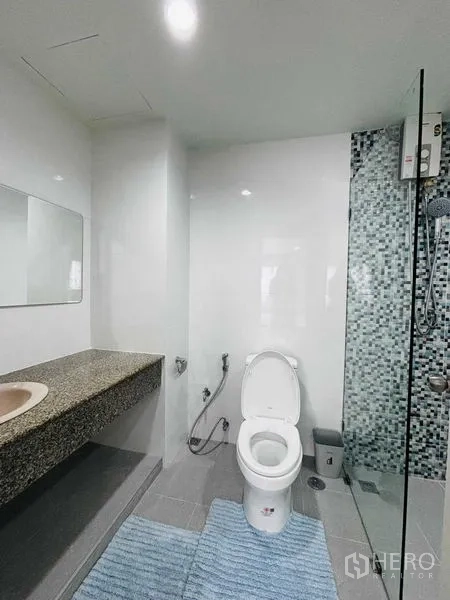 Condominium for rent in Watthana, Bangkok - Bright bathroom with vanity counter, toilet and walk-in shower.
