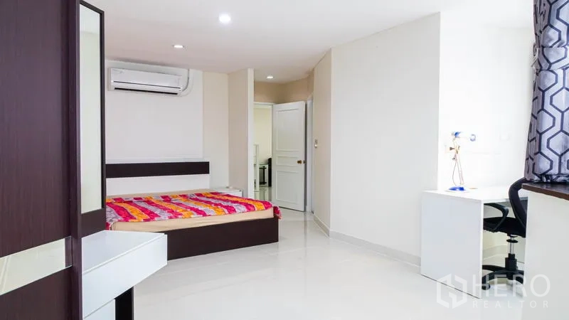 公寓 出租或出售在Khlong Toei, Bangkok - 宽敞卧室，配床、书桌、衣柜与空调。