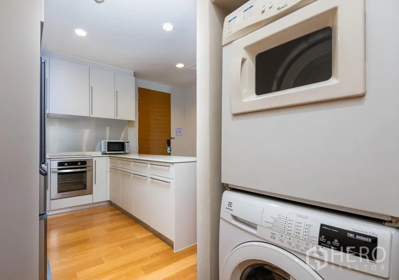 Condominium for rent in Bang Kho Laem, Bangkok - Utility area with stacked washer and dryer next to the kitchen.
