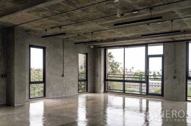 Office Space for rent or sale in Lak Si, Bangkok - Bright open-plan workspace with floor-to-ceiling windows and a side glass door.