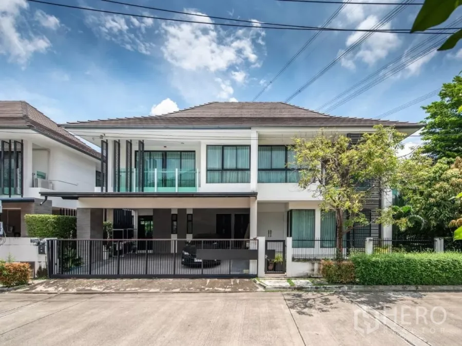 Detached House for rent or sale in Prawet, Bangkok - Modern two-storey detached house facade with gated 3-car covered parking and landscaped frontage.
