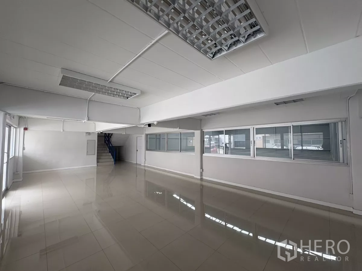 工厂 出租在Bang Phli, Samut Prakan - 一层办公室空间宽敞，亮面地砖与荧光灯，并设室内楼梯。