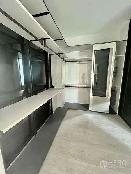 独立式住宅 出租或出售在Bang Phli, Samut Prakan - 定制步入式衣帽间，带内置层架、玻璃柜门与长梳妆台。