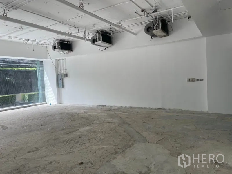 พื้นที่ขายปลีก ให้เช่าในWatthana, Bangkok - ภาพระยะใกล้ผนังสีขาว เครื่องปรับอากาศแขวนเพดาน และตู้ไฟ พร้อมปรับโฉม