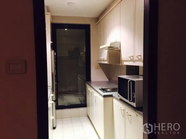 คอนโด ให้เช่าในSathon, Bangkok - ครัวรูปแกลเลย์ขนาดกะทัดรัด ตู้สีขาว เตาไฟฟ้า เครื่องดูดควัน ไมโครเวฟ และประตูกระจก