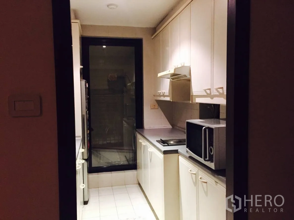 คอนโด ให้เช่าในSathon, Bangkok - ครัวรูปแกลเลย์ขนาดกะทัดรัด ตู้สีขาว เตาไฟฟ้า เครื่องดูดควัน ไมโครเวฟ และประตูกระจก