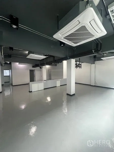 零售空间 出租在Watthana, Bangkok - 宽敞店铺内部，承重柱与天花嵌入式空调，工业风灰色天花。