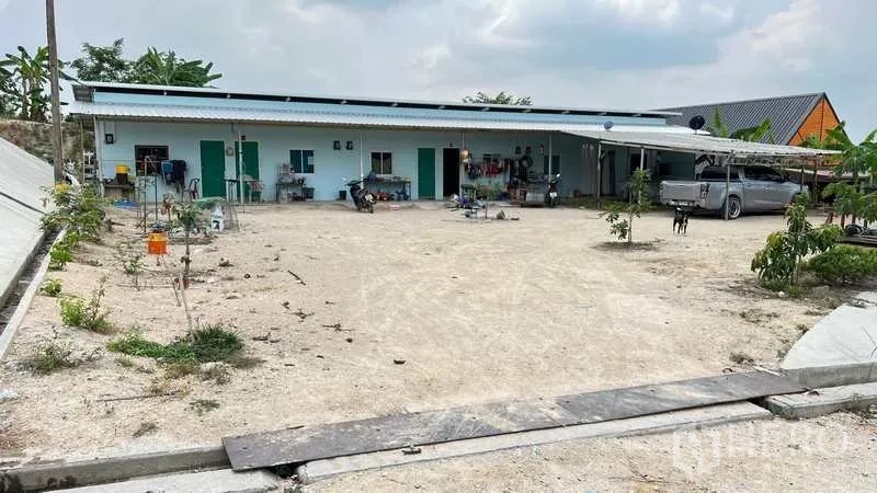 工厂 出售在Nikhom Phatthana, Rayong - 园区单层员工宿舍排屋，前方宽阔停车空地。