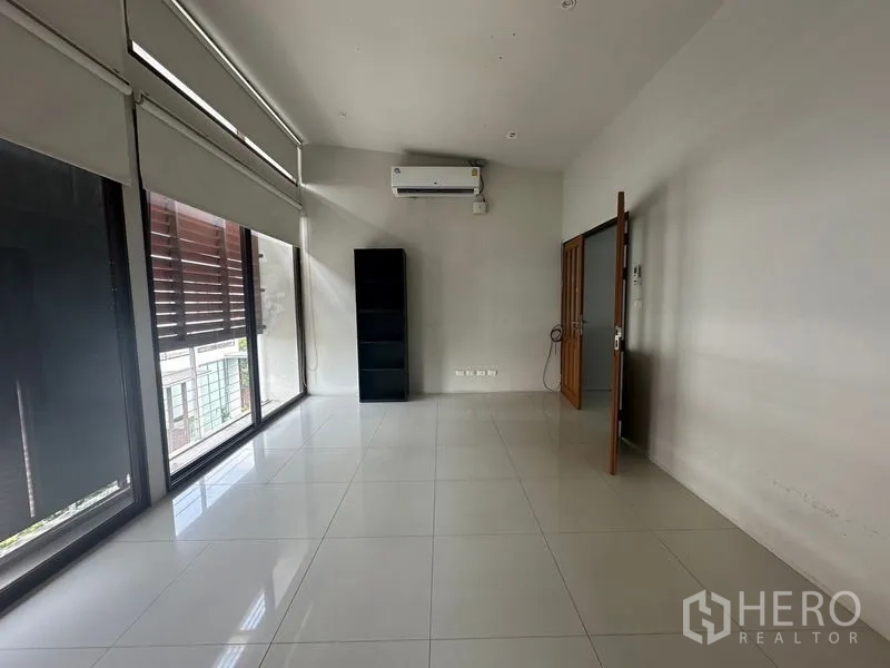 Home Office for rent in Phra Khanong, Bangkok - Bright tiled room with roller blinds, air conditioner and full-height windows.