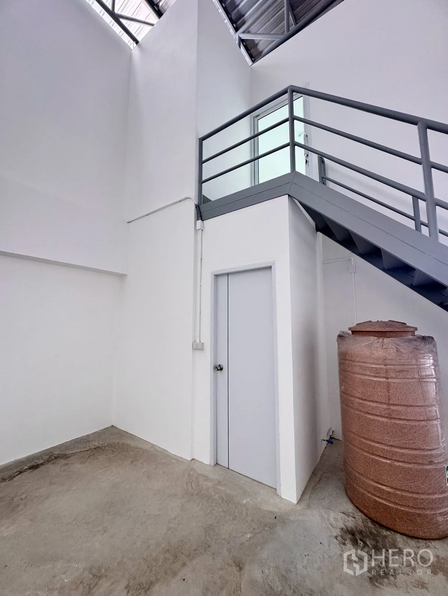 โกดัง for rent in Bang Bo, Samut Prakan - มุมพื้นล่างมีบันไดเหล็กขึ้นสู่ชั้นบนและถังเก็บน้ำข้างประตู