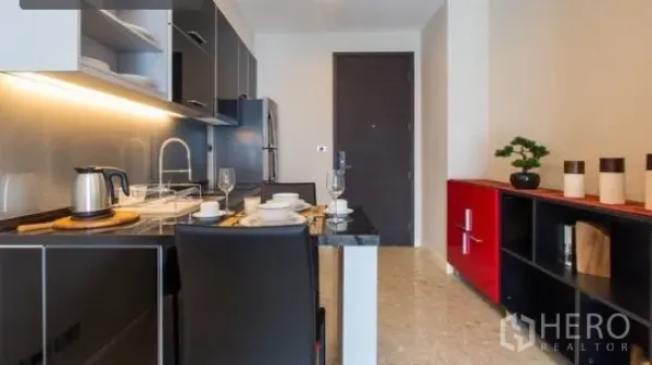 公寓 出租在Khlong Toei, Bangkok - 开放式小厨房配双人餐位、入户门与红色收纳柜。