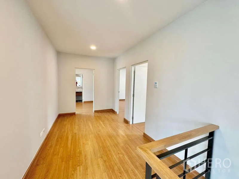 Detached House for sale in Bang Phli, Samut Prakan - Upper hallway with wood flooring leading to bedrooms and bathrooms.