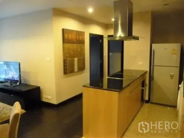 คอนโด ให้เช่าในSathon, Bangkok - ครัวแบบเปิดพร้อมไอส์แลนด์ เตาไฟฟ้า เครื่องดูดควัน และตู้เย็น ติดกับโซนนั่งเล่น