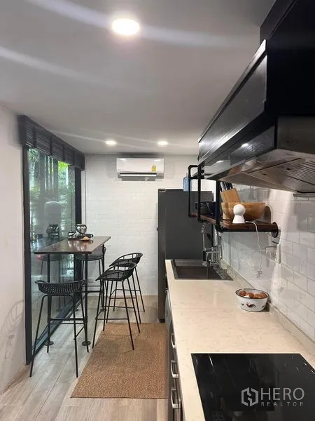 ทาวน์เฮาส์ ขายในWang Thonglang, Bangkok - ครัวแนวยาวพร้อมโต๊ะบิสโทรและวิวต้นไม้