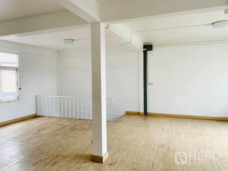 อาคารพาณิชย์ ให้เช่าหรือขายในKhlong Toei, Bangkok - ห้องชั้นบนโล่ง พื้นลายไม้ ผนังสีขาว เสากลาง และหน้าต่างข้างโถงบันได