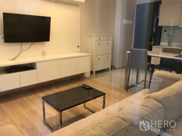 คอนโด ให้เช่าหรือขายในWatthana, Bangkok - ห้องนั่งเล่นสว่างมีโซฟา ทีวีติดผนัง และครัวแบบเปิดสไตล์โมเดิร์น