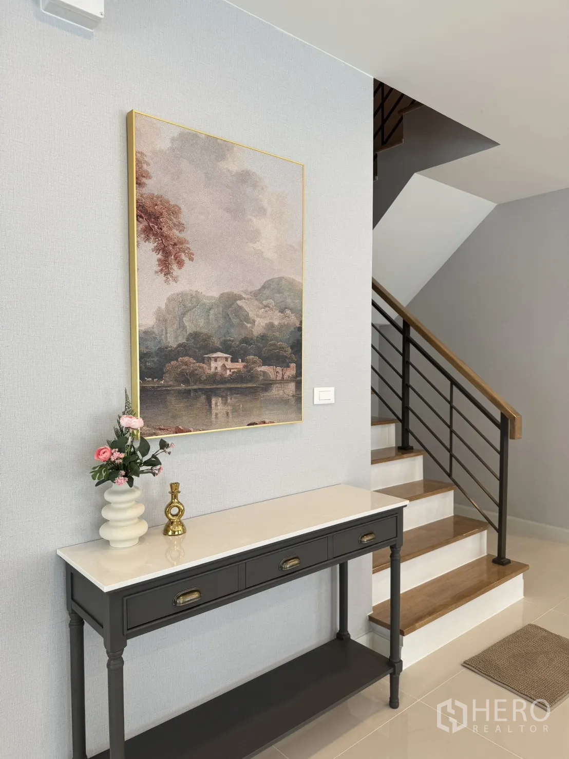 Detached House for rent in Bang Phli, Samut Prakan - Entry foyer with console table, artwork, flowers and modern staircase with wooden steps.