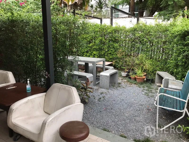 พื้นที่ขายปลีก ให้เช่าในWatthana, Bangkok - มุมสวนกรวด เก้าอี้คอนกรีต และแนวรั้วพุ่มไม้