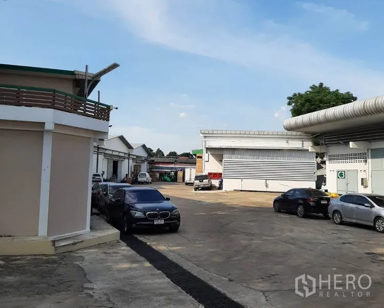 Warehouse for rent in Suan Luang, Bangkok - Paved warehouse compound in Suan Luang with parking, wide driveway and multiple loading bays.