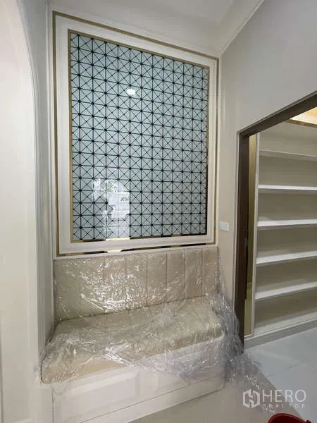 Detached House for sale in Thawi Watthana, Bangkok - Window seat with upholstered bench and geometric decorative panel beside shelving