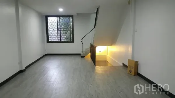 อาคารพาณิชย์ ให้เช่าในWatthana, Bangkok - พื้นที่ชั้นล่างแบบโอเพ่นพร้อมพื้นลายไม้ หน้าต่างติดเหล็กดัด และบันไดขึ้นชั้นบน.