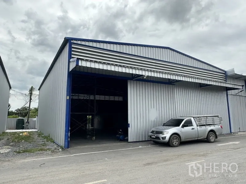 货栈 出租在Khlong Luang, Pathum Thani - 仓库正立面，4×4米大滑门与带雨棚的装卸区。