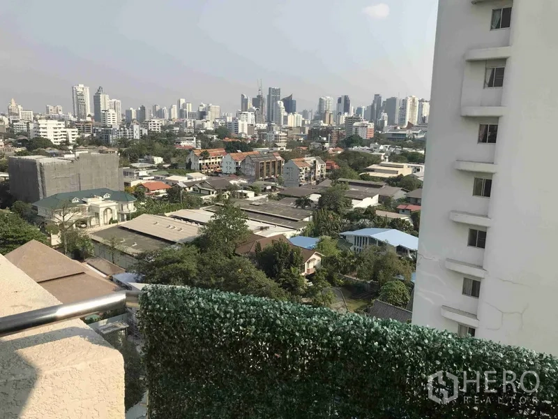 公寓 出租或出售在Watthana, Bangkok - 阳台设绿化围栏，俯瞰瓦塔那区城市天际线。