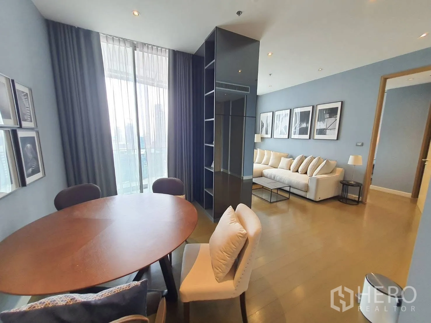 คอนโด for rent in Pathum Wan, Bangkok - มุมรับประทานอาหารแบบเปิด โต๊ะไม้ทรงกลม เก้าอี้บุนวม ข้างหน้าต่างสูงจรดเพดาน