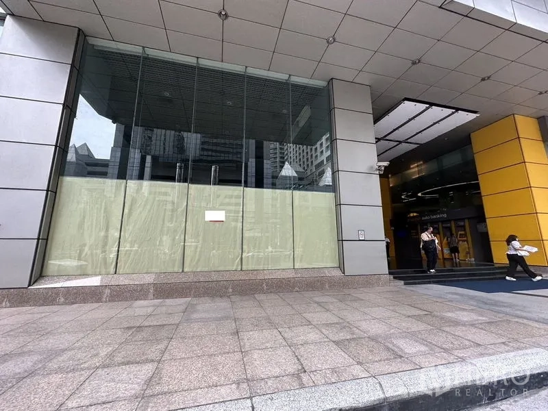 พื้นที่ขายปลีก ให้เช่าในWatthana, Bangkok - ด้านหน้าร้านกระจกของอาคารพาณิชย์สมัยใหม่ในย่านสุขุมวิท พร้อมขั้นบันไดหินแกรนิตและทางเข้าแบบมีหลังคา.