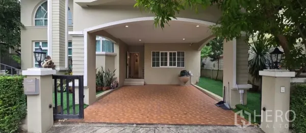 独立式住宅 出租在Mueang Pathum Thani, Pathum Thani - 有顶车棚与入口，铺砖车道及花园一角