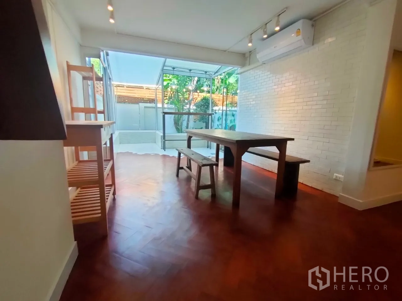 零售空间 出租在Khlong Toei, Bangkok - 用餐或会议区，旁接明亮的玻璃房，白砖墙与空调。