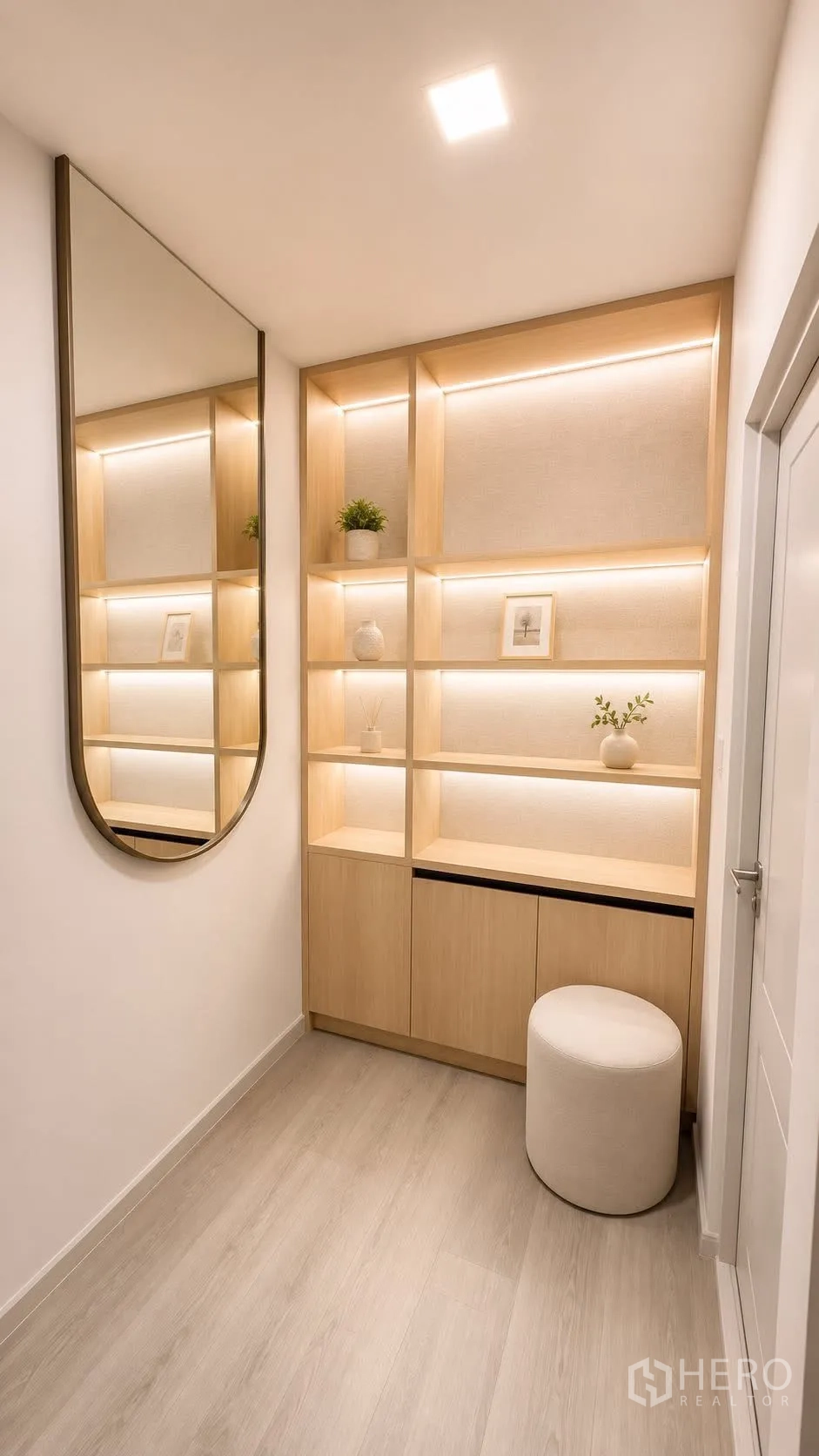 Detached House for rent or sale in Bang Phli, Samut Prakan - Hall niche with illuminated built-in shelving, large mirror, and round stool.