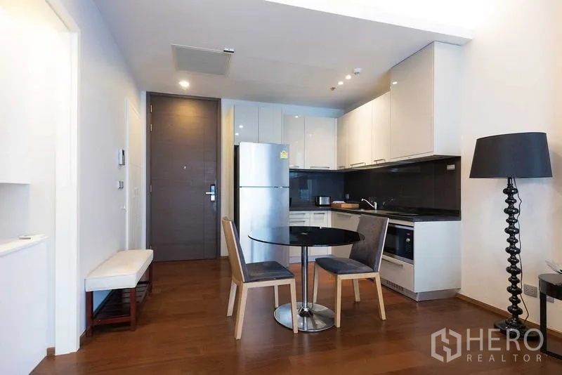 Condominium for rent - Open kitchen and dining zone with bench seating and a black floor lamp.