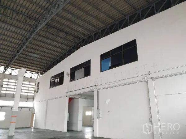 工厂 出租在Bang Pakong, Chachoengsao - 厂房内的两层办公室近景，设有窗户可俯瞰生产大厅。