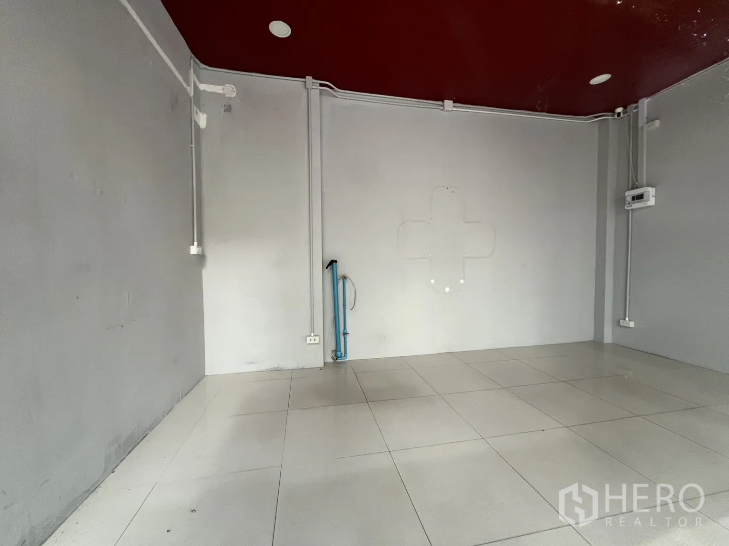 零售空间 for rent in Watthana, Bangkok - 空置零售室内，白色地砖，外露电管与酒红色天花，预留管线接口。