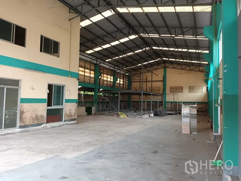 Warehouse for rent in Phasi Charoen, Bangkok - Open-plan industrial space with skylights, steel columns and partial mezzanine.