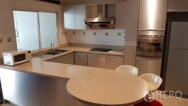 ทาวน์เฮาส์ ให้เช่าหรือขายในKhlong Toei, Bangkok - ครัวรูปตัว U ทันสมัยพร้อมเคาน์เตอร์บาร์ อ่างล้างคู่ ผนังกระเบื้อง และเครื่องใช้สแตนเลส